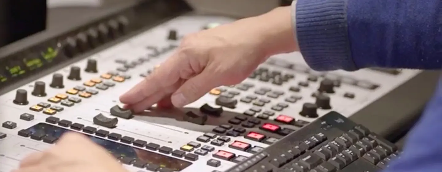 A person adjusting a slider on the sound and media board 