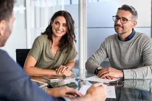 Three people sitting down and talking at a table